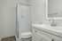 Sleek and modern bathroom featuring a frameless glass shower, elegant vanity with a stylish chrome faucet, and calming neutral tones.