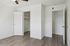 Bright and modern bedroom with elegant wood flooring and spacious walk-in closet.
