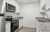 Modern kitchen with sleek granite countertops, stainless steel appliances, and crisp white cabinets, perfect for culinary enthusiasts.