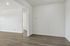Chic and modern apartment showcasing elegant laminate wood floors, pristine white walls, and ambient recessed lighting.