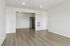 Modern apartment interior featuring sleek hardwood floors, open layout, and a stylish stainless steel refrigerator in the kitchen area.