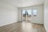 Bright, spacious room with sleek wood flooring and large sliding glass doors opening to a serene balcony view.