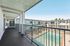 Spacious apartment balcony overlooking a sparkling community pool, perfect for relaxation and leisure.