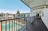 Inviting balcony view overlooking a serene swimming pool and modern apartment complex, perfect for relaxation and leisure.