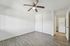 Bright bedroom with stylish wood flooring, ceiling fan, and convenient in-unit washer and dryer.