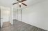 Bright and airy bedroom with sleek hardwood floors, mirrored sliding closet doors, and a modern ceiling fan, offering a clean and inviting atmosphere.