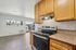 Bright and modern kitchen with sleek appliances, granite countertops, and warm wooden cabinets, offering an inviting and functional cooking space with a view.