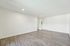 Spacious living room with sleek hardwood floors and bright recessed lighting, ideal for modern living.
