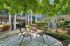 Charming apartment outdoor space with cozy patio chairs surrounded by lush greenery and modern architecture.