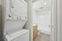 Modern apartment bathroom with crisp white fixtures and convenient in-unit washer and dryer.