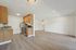 Charming open-plan living area with modern kitchen, featuring sleek stainless steel appliances, elegant cabinetry, and inviting hardwood floors.