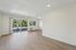 Bright and airy living room with elegant wood flooring and large window opening to a scenic view, ideal for relaxation and entertaining.