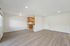 Bright and spacious open-concept living area with modern laminate flooring and a cozy kitchen nook featuring elegant wood cabinetry.
