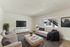 Bright and modern living room with stylish decor, featuring plush seating and large flat-screen TV, perfect for relaxation.