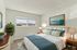 Bright and inviting bedroom with modern decor, featuring a large window, elegant artwork, and stylish furniture.