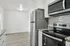 Modern kitchen with sleek stainless steel appliances, granite countertops, and bright white cabinetry.