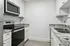 Modern kitchen with sleek granite countertops, stainless steel appliances, and elegant white cabinetry.