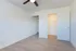 Bright and airy bedroom with elegant ceiling fan, spacious closet, and modern wooden flooring.