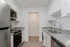 Modern kitchen with sleek stainless steel appliances, elegant granite countertops, and white cabinetry for a clean, sophisticated look.