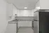 Modern kitchen with sleek white cabinetry, granite countertops, and stainless steel appliances.