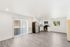 Bright open-concept kitchen and living area with modern stainless steel appliances and sliding glass door leading to a cozy patio.