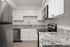 Modern kitchen with sleek stainless steel appliances, white cabinetry, and granite countertops, offering a stylish and functional cooking space.