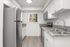 Modern kitchen with stainless steel appliances, white cabinetry, and granite countertops offering a sleek and bright cooking space.