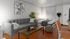 Stylish studio apartment featuring a modern gray sofa, cozy bed, wooden accents, and vibrant wall art.