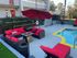 Inviting outdoor lounge with red cushioned seating by a sparkling pool and umbrella shade.