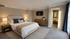 Elegant bedroom featuring a cozy double bed, stylish bedside tables with warm lighting, modern decor, a sleek TV, and large windows for natural light.