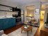 Chic apartment interior with a modern kitchen, teal cabinetry, cozy dining area, and inviting living space.