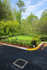Charming fenced green space with lush trees and vibrant plants, ideal for outdoor relaxation in a serene environment.