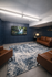 Contemporary sitting room with elegant blue accent wall, plush leather seating, and a captivating waterfall artwork.