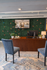 Charming office setup with a vibrant green wall adorned with colorful butterflies, featuring a sleek wooden desk, modern blue chairs, and a cozy atmosphere