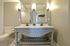 Elegant bathroom with dual sink vanity, decorative mirrors, and warm lighting creates a cozy and inviting atmosphere.