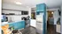Modern kitchen with sleek blue cabinets, stainless steel appliances, and an inviting dining area with natural lighting.