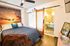 Cozy bedroom featuring modern decor, sunset wall mural, and sliding barn door leading to a stylish en-suite bathroom.