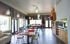 Modern communal dining area with stylish pendant lights, colorful chairs, and an inviting natural ambiance.