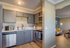 Modern kitchen with sleek gray cabinets, stainless steel appliances, and inviting open layout leading to a cozy living area.