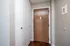 Inviting entryway featuring sleek white storage closets and a warm wooden door, enhanced by elegant hardwood flooring.