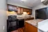 Elegant kitchen featuring modern black appliances, rich wooden cabinets, and granite countertops offering both style and functionality.