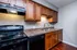 Modern kitchen showcasing rich wooden cabinetry, sleek countertops, and stainless steel sink with contemporary fixtures.