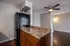 Modern kitchen with sleek black refrigerator, spacious countertop, and elegant cabinetry overlooking a stylish open-concept living area with hardwood flooring.