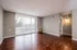 Modern living room with elegant hardwood flooring, large windows, and abundant natural light.
