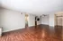 Inviting open-floor apartment with elegant wood flooring, a ceiling fan, and abundant natural light, perfect for comfortable modern living.