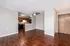 Modern open-concept living space with rich wooden flooring, sleek kitchen cabinets, and a cozy atmosphere.