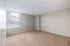 Bright and airy room with soft carpet flooring and a large window, perfect for a cozy bedroom retreat.