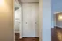 Inviting hallway with a spacious closet and sleek wood flooring in a modern apartment.
