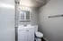 Elegant modern bathroom featuring sleek white cabinetry, sparkling sink, and contemporary mirror lighting.