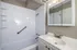 Elegant modern bathroom with sleek white fixtures, ample mirror storage, and bright lighting for a refreshing experience.